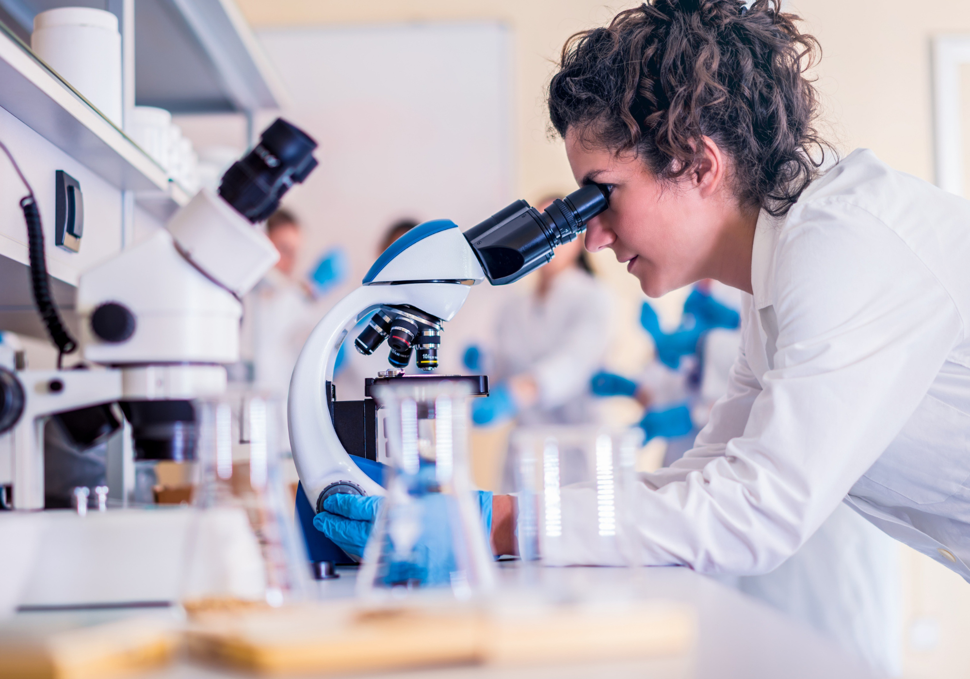 Mujer mirando a través de un microscopio